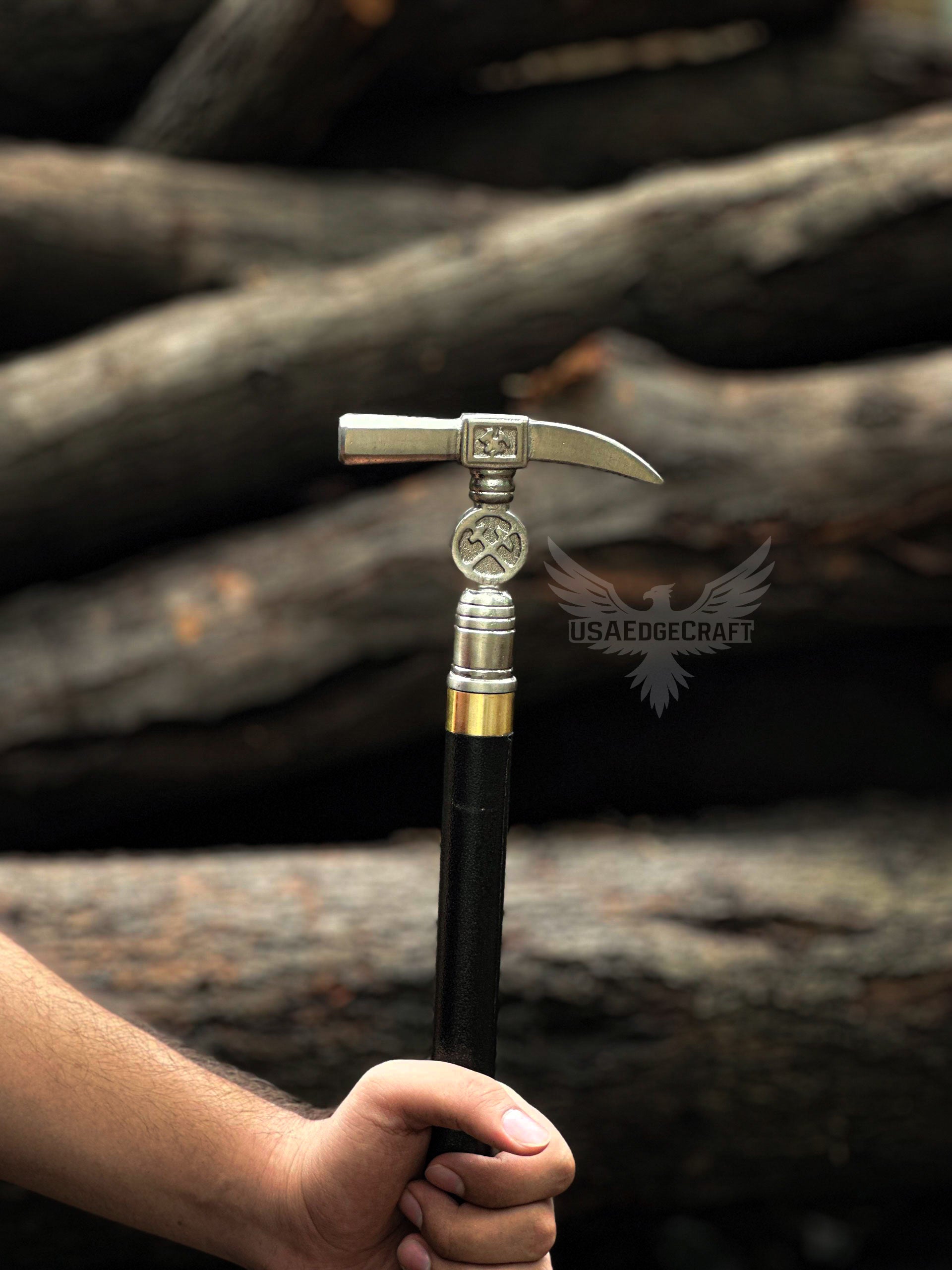 Detailed close-up of antique silver hammer head handle on hand-forged sword cane with polished black metal shaft and stainless steel blade.
